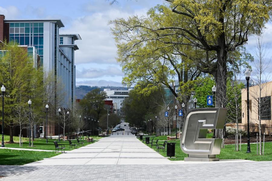 Silver Power C on Campus A view of the tree-lined Vine Street Pedestrian Mall on the UTC Campus, including the stainless-steel "Power C" logo sculpture, Derthick Hall and the UTC Library, with the Unum building in the background.