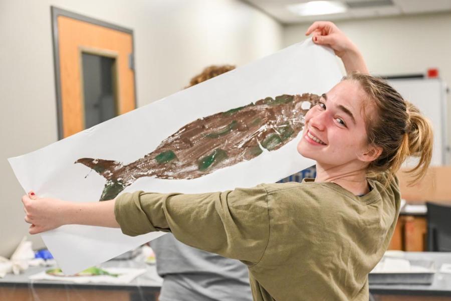 Amazing Biology of Fishes Honors student holds up art from her Amazing Biology of Fishes class.
