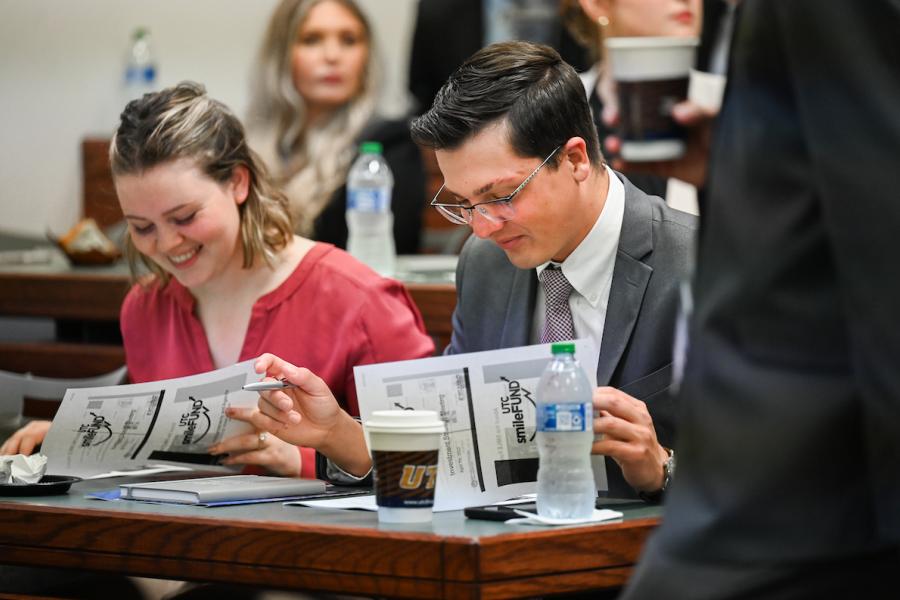 Students looking through papers that say smile fund. 