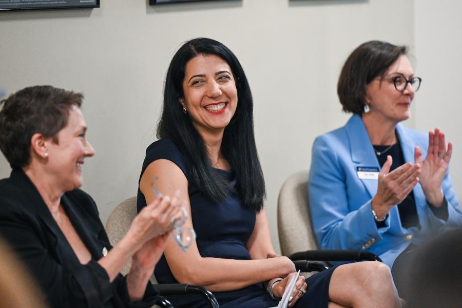 Mini Sartipi, Director of the Research Institute, smiling as she speaks to a woman sitting next to her.