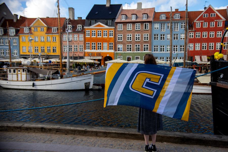 UTC international students holding a flag abroad