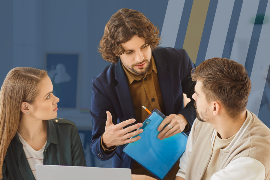 Man holds a clipboard while standing and talking to a man and a woman about business.