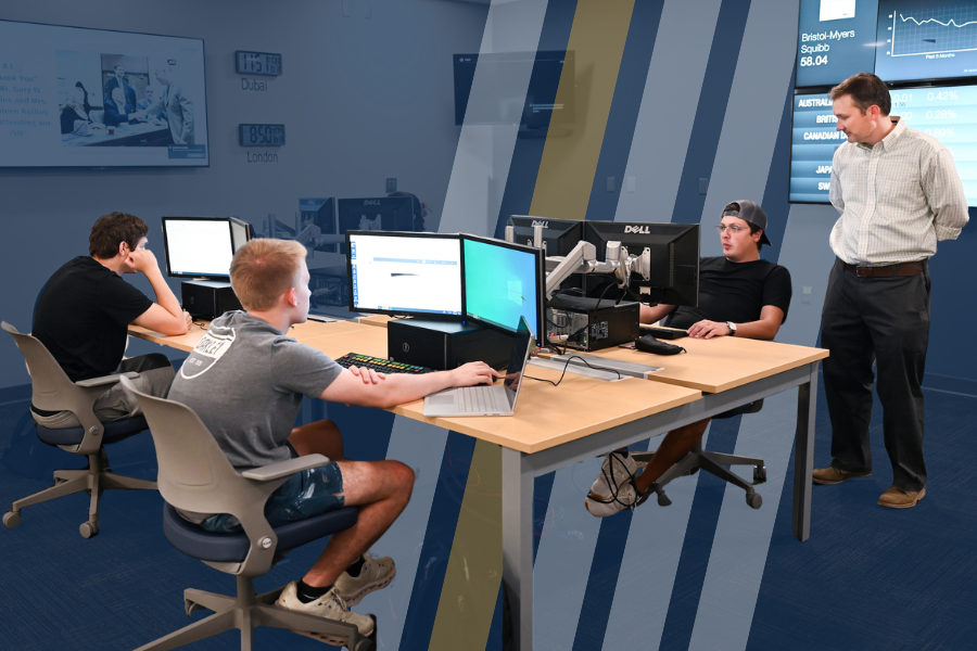 RCOB students work on computers in the Bloomberg Lab as Dr. Hunter Holzhauer looks on. 