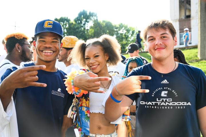 Students displaying Power C hand sign at the 2022 Homecoming game