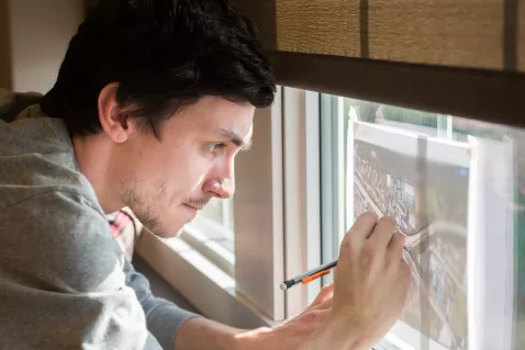UTC Geography student sketching a map on a window